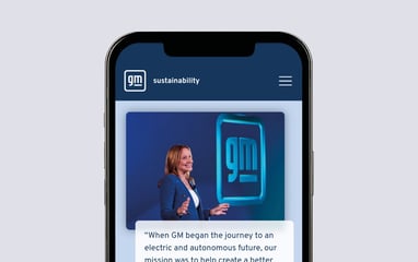 The GM sustainability microsite on a mobile phone. An image of Mary T. Barra presenting with the GM logo in the background